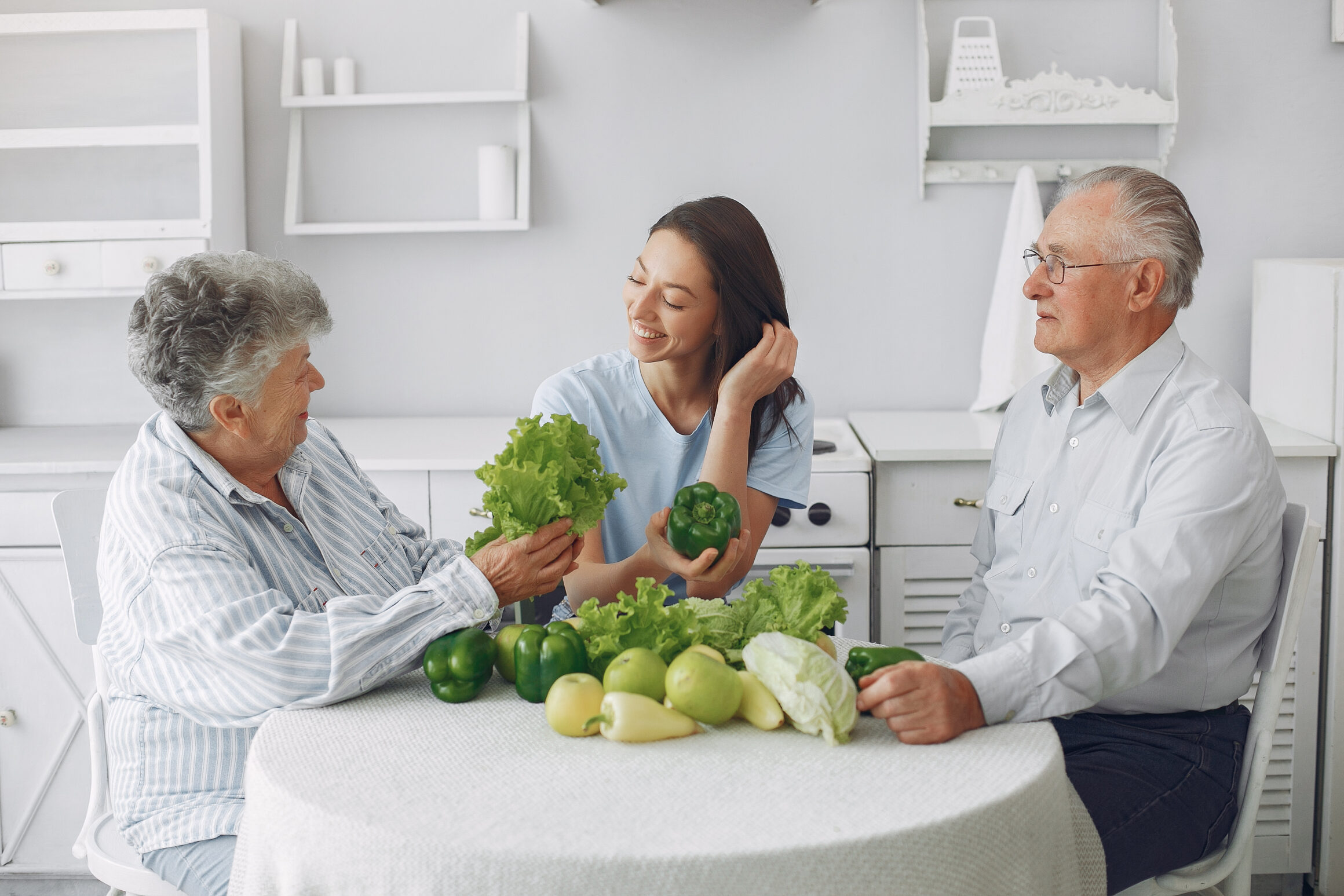 Old couple in a kitchen with young granddaughter